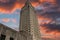 The Louisiana State Capitol building with lush green trees and powerful clouds at sunset in Baton Rouge Louisiana