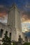 The Louisiana State Capitol building with lush green trees and powerful clouds at sunset in Baton Rouge Louisiana