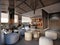 Lounge area with white pouffes and meeting room with wicker chairs in loft eco style office interior