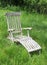 Lounge chair in wildly grown field of grass.