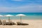 Lounge chairs with sun umbrella on a beach. Sun of summer time on sky and sand of beach relaxation landscape viewpoint.