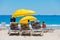 Lounger chairs and parasol umbrellas on sandy beach in Cape Town