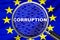 Loupe focused on the word corruption on EU flag background. Corruption, financial concept in European Union