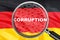 Loupe focused on the word corruption on Germany flag background. Corruption, financial concept in Germany