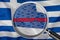 Loupe focused on the word corruption on Greece flag background. Corruption, financial concept in Greece