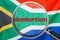 Loupe focused on the word corruption on South Africa flag background. Corruption, financial concept in South Africa