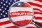 Loupe focused on the word corruption on US flag background. Corruption, financial concept in USA