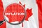 Loupe focused on the word inflation on Canada flag background. Inflation, tax, financial concept in Canada