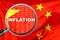 Loupe focused on the word inflation on China flag background. Inflation, tax, financial concept in China
