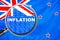 Loupe focused on the word inflation on New Zealand flag background. Inflation, tax, financial concept in New Zealand