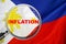 Loupe focused on the word inflation on Philippines flag background. Inflation, tax, financial concept in Philippines