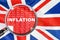 Loupe focused on the word inflation on UK flag background. Inflation, tax, financial concept in Britannia