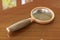 Loupe, magnifier, magnifying glass on the wooden table, 3D rendering