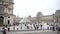 Louvre Museum in Paris with people admiring the Pyramid and museum