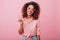 Lovable african girl in cute sunglasses posing on pink background with pleasure. Charming curly woman in vintage outfit