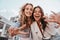 Lovable caucasian girls expressing positive emotions to camera. Outdoor photo of refined sisters posing on sky