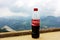 LOVCHEN, MONTENEGRO - July 16, 2012: Plastic bottle of Coca-Cola drink against nature background with mountains