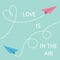 Love is in the air Lettering text. Two flying origami paper plane.