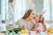 We love beautiful traditions.Mom and daughter paint eggs, dad holds a home decorative rabbit