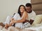 Love, black couple on bed and play together for bonding, loving and romantic weekend. Romance, man and woman in bedroom