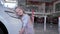 Love for cars, happy smiling kid girl hugs automobile headlight in auto showroom