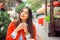 Love for cofee. Portrait of cute girl drinking tea on the balcony over outside green terrace background, wearing red jacket and