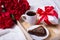 love concept - breakfast with cake, tea and little gift on wooden tray and red flowers