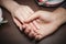 love concept -close up of engaged couple holding hands with diamond ring over holidays lights background