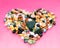 Love concept.Heart-shaped decoration from colorful pebbles on a pink background.choco rocks looks like pebbles