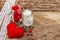 Love concept for Valentines day or mothers day. Red felt heart, glass jar, roses, ribbons. Old wooden boards background