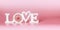 Love concept with white word love at pastel pink background. Creative romantic layout. Wedding card. Copy space. Banner. Greeting