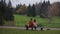 Love couple on bench. Young couple sitting on bench in park. Rear view. A couple is sitting on a bench contemplating