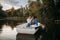 Love couple hugs in a boat on quiet lake at sunset