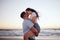 Love, couple and kiss on beach at sunset for romantic and passionate embrace on summer evening date. Dating USA woman
