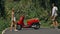 Love couple on red motorbike in white clothes, sunglasses on forest road trail trip. Dancing road. Two caucasian tourist