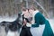 Love couple with Siberian husky in snowy winter forest