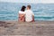 Love couple sitting on a pier overlooking the sea