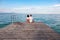 Love couple sitting on a pier overlooking the sea