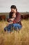 Love, family and care with a mother and daughter hugging in a field outside on a farm. Cattle farmer and little girl in