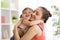 Love and family people concept - happy mother and child daughter hugging at home