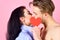 Love and foreplay. Celebrate valentines day. Romantic kiss concept. Couple in love kissing and hide lips behind heart