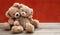 Love, friendship concept, tight hug. Teddy bears couple on wooden floor, red wall background
