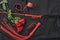 Love games. Top view of bdsm leather kit handcuffs, whip and beautiful red roses against of black silk fabric