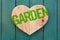 Love garden message wooden heart on turquoise painted background