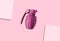love grenade, pink grenade filled with love on a pink background between two papers