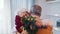 Love and happines. Elderly man giving red roses to his wife on womens day