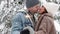 love, happiness and romance concept - couple posing with sparklers and kissing in winter forest