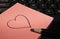 Love heart drawn on sticky note by keyboard