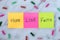 Love, hope, and faith handwritten words on colorful notes with decorative clothespins on white marble background