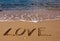 Love - the inscription on the sand near sea